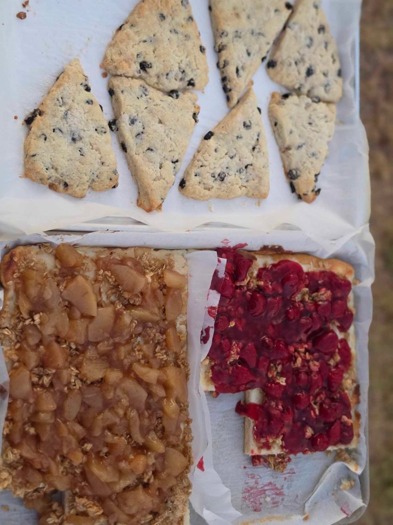 A tray of scones beside apple and berry breakfast pastries from Jenn's Cottage Bakery