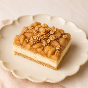 Apple granola cheesecake bar on a cream scalloped plate
